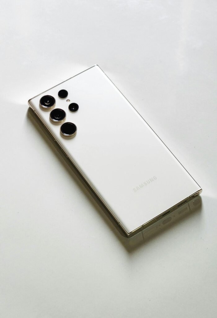 pexels-photo-16149966-16149966 Sleek white smartphone displayed on a smooth white surface, emphasizing modern design.